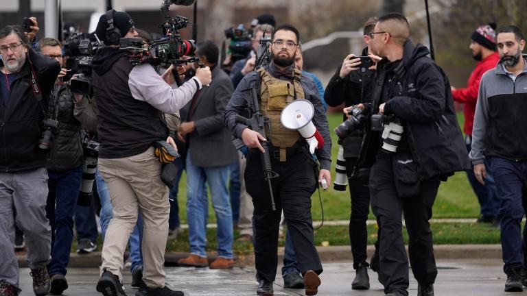 A protester carrying a rifle leaves the Kenosha County Courthouse after speaking with Kenosha County Sheriffs Department officers, Wednesday, Nov. 17, 2021 in Kenosha, Wis., during the Kyle Rittenhouse murder trial. (AP Photo / Paul Sancya)