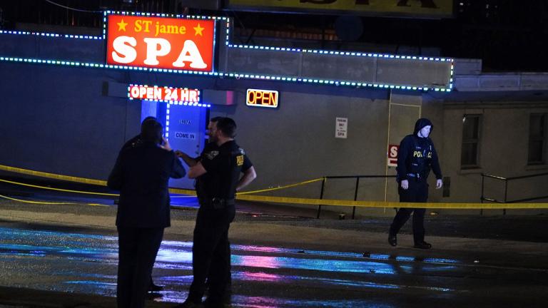 Law enforcement officials confer outside a massage parlor following a shooting on Tuesday, March 16, 2021, in Atlanta. (AP Photo / Brynn Anderson)