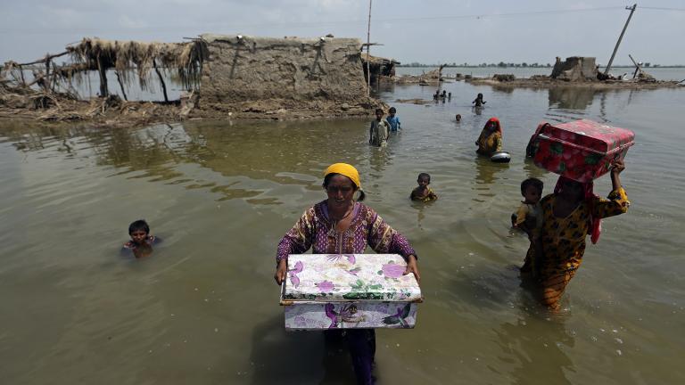 Women carry belongings salvaged from their flooded home after monsoon rains, in the Qambar Shahdadkot district of Sindh Province, of Pakistan, Tuesday, Sept. 6, 2022. (AP Photo / Fareed Khan)