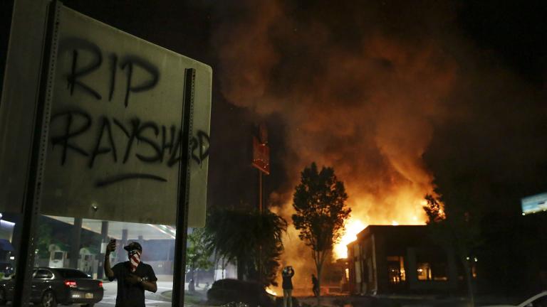 “RIP Rayshard” is spray painted on a sign as flames engulf a Wendy’s restaurant during protests Saturday, June 13, 2020, in Atlanta. (AP Photo / Brynn Anderson)