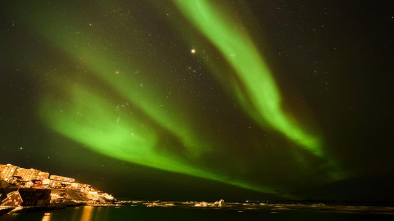 The northern lights appear over homes in Nuuk, Greenland, Monday, Feb. 17, 2025. (AP Photo/Emilio Morenatti)