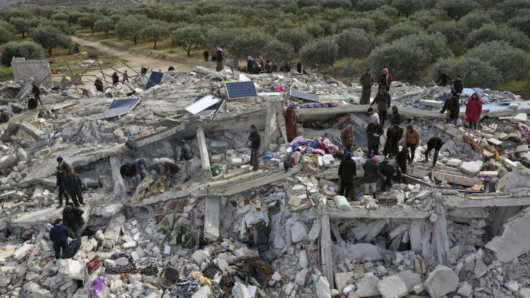 Civil defense workers and residents search through the rubble of collapsed buildings in the town of Harem near the Turkish border, Idlib province, Syria, Monday, Feb. 6, 2023. A powerful earthquake has caused significant damage in southeast Turkey and Syria and many casualties are feared. (AP Photo/Ghaith Alsayed)