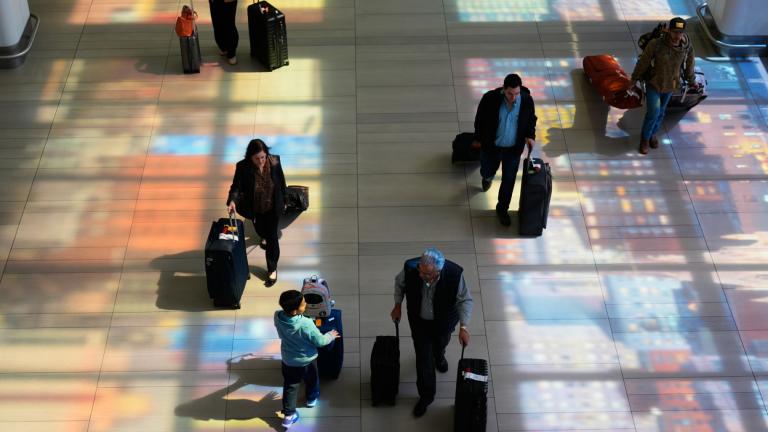 Stained-glass windows cast colorful shadows on the floor as travelers walk through LaGuardia Airport in New York, Monday, March 30, 2026. (AP Photo / Seth Wenig)