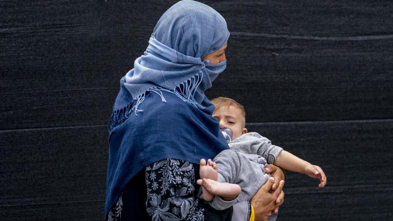 A woman evacuated from Afghanistan steps off a bus with a baby as they arrive at a processing center in Chantilly, Monday, Aug. 23, 2021, after arriving on a flight at Dulles International Airport. (AP Photo / Andrew Harnik)