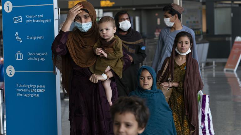 Families evacuated from Kabul, Afghanistan, walk through the terminal before boarding a bus after they arrived at Washington Dulles International Airport, in Chantilly, Va., on Friday, Aug. 27, 2021. (AP Photo / Jose Luis Magana)
