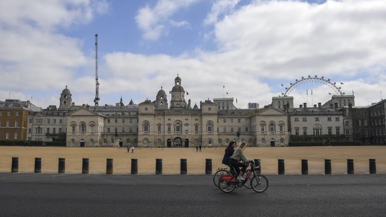 Two women ride bicycles past the Horse Guards Parade, during lockdown due to the coronavirus outbreak, in London, Saturday, April 25, 2020.(AP Photo/Alberto Pezzali)