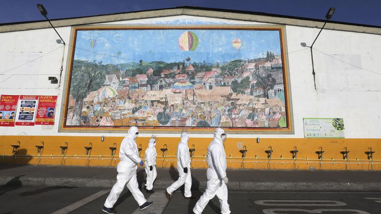 Workers in protective body suits walk past sinks for hand washing at the “Corabastos,” one of Latin America’s largest food distribution centers, as they work to disinfect it to help contain the spread of the new coronavirus in Bogota, Colombia, Friday, April 10, 2020. (AP Photo / Fernando Vergara)