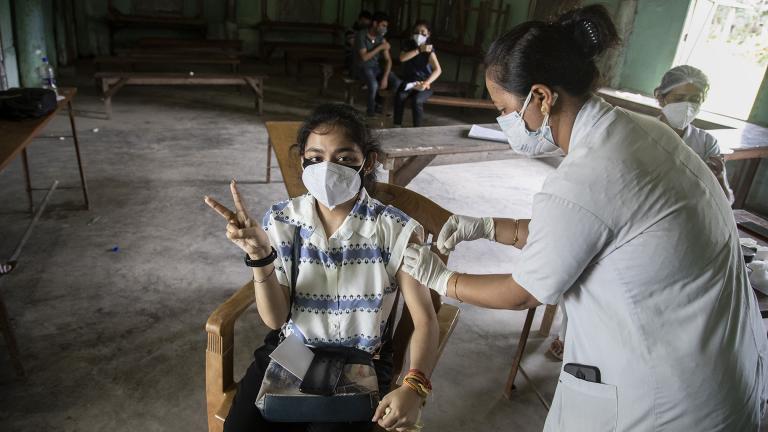 An Indian woman getting vaccinated with a dose of COVAXIN against the coronavirus gestures to camera in Gauhati, Assam, India, Monday, May 10, 2021. (AP Photo / Anupam Nath)