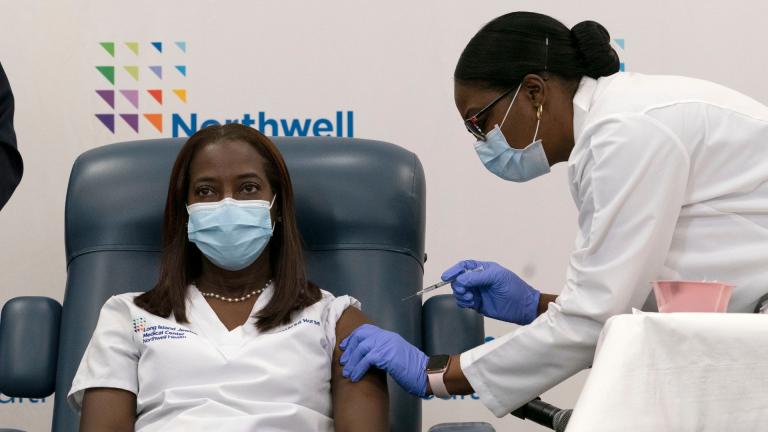 Sandra Lindsay, left, a nurse at Long Island Jewish Medical Center, is inoculated with the Pfizer-BioNTech COVID-19 vaccine by Dr. Michelle Chester, Monday, Dec. 14, 2020, in the Queens borough of New York. (AP Photo / Mark Lennihan, Pool)