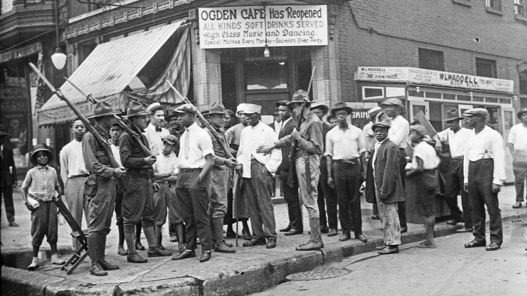 In this 1919 photo provided by Chicago History Museum, a crowd of men and armed National Guard stand in front of the Ogden Cafe during race riots in Chicago. (Chicago History Museum / The Jun Fujita negatives collection via AP) In this 1919 photo provided by Chicago History Museum, a crowd of men and armed National Guard stand in front of the Ogden Cafe during race riots in Chicago. (Chicago History Museum / The Jun Fujita negatives collection via AP)