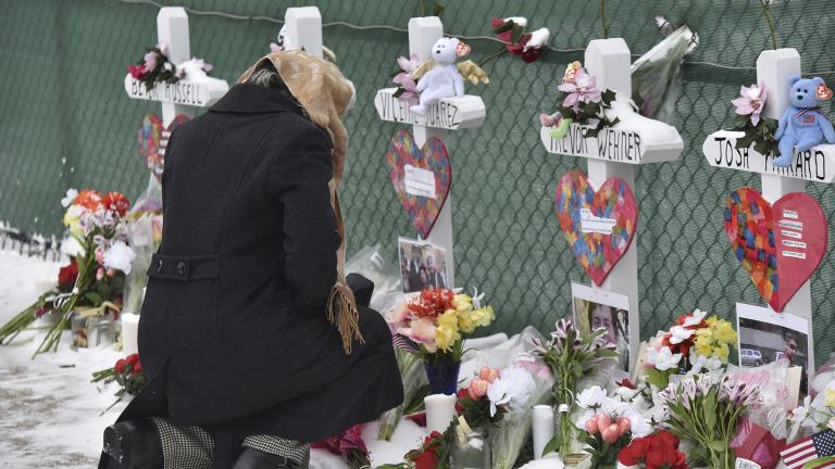 Mourners place flowers at the crosses outside of the Henry Pratt Co. in Aurora, Illinois, on Sunday, Feb. 17, 2019, in memory of the five employees killed on Friday. (Jeff Knox / Daily Herald via AP)