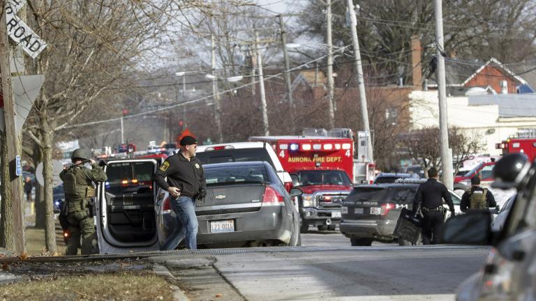 Law enforcement personnel gather near the scene of a shooting at an industrial park in Aurora, Illinois, on Friday, Feb. 15, 2019. (Bev Horne / Daily Herald via AP)