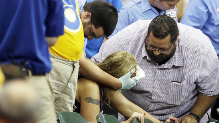 In this July 6, 2015 file photo, a fan is helped after being hit by a foul ball during the ninth inning of a baseball game between the Milwaukee Brewers and the Atlanta Braves in Milwaukee. (AP Photo / Morry Gash, File)