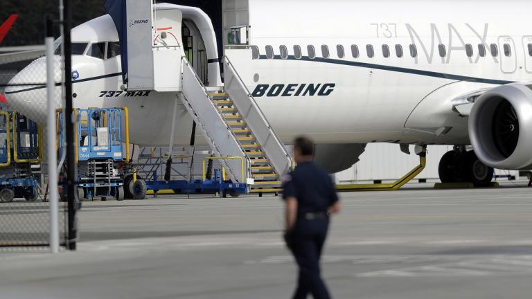 In this March 14, 2019, file photo a worker walks next to a Boeing 737 MAX 8 airplane parked at Boeing Field in Seattle. (AP Photo / Ted S. Warren, File)