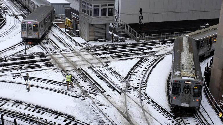 CTA trains move along snow-covered tracks Monday, Jan. 28, 2019, in Chicago. (AP Photo / Kiichiro Sato)