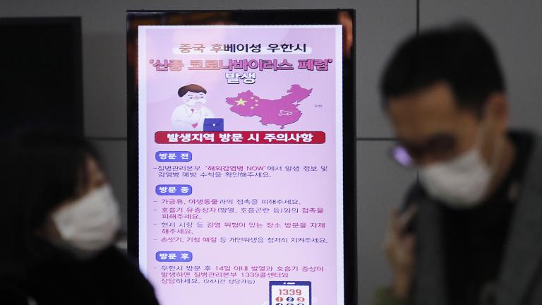 In this Jan. 27, 2020, file photo, a poster warning about coronavirus is seen as passengers wear masks in a departure lobby at Incheon International Airport in Incheon, South Korea. (AP Photo / Ahn Young-joon, File)