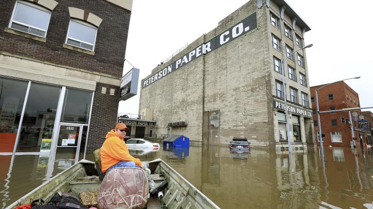 Ryan Lincoln maneuvers his boat through floodwater in downtown Davenport, Iowa, on Thursday, May 2, 2019. (Kevin E. Schmidt / Quad City Times via AP)