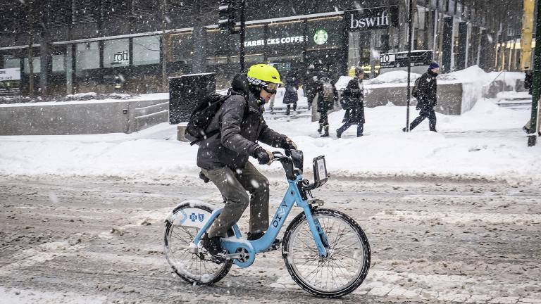 A person navigates a snowy Adams Street on a Divvy bicycle on Monday, Jan. 28, 2019. (Rich Hein / Chicago Sun-Times via AP)