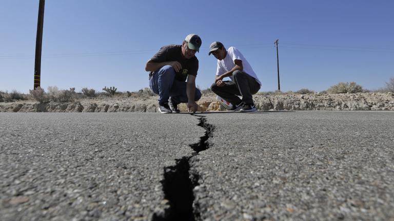Ron Mikulaco, left, and his nephew, Brad Fernandez, examine a crack on Highway 178 caused by an earthquake Saturday, July 6, 2019, outside of Ridgecrest, California. (AP Photo / Marcio Jose Sanchez)