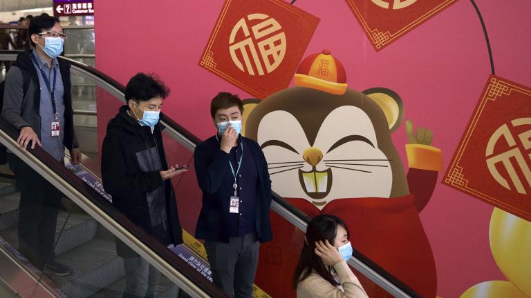 People wear face masks as they ride an escalator at the Hong Kong International Airport in Hong Kong, Tuesday, Jan. 21, 2020. (AP Photo / Ng Han Guan) People wear face masks as they ride an escalator at the Hong Kong International Airport in Hong Kong, Tuesday, Jan. 21, 2020. (AP Photo / Ng Han Guan)