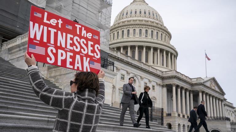 Laura Albinson of Pasadena, Md., displays a message for members of the House as they leave the Capitol in Washington, Friday, Jan. 10, 2020. (AP Photo / J. Scott Applewhite)
