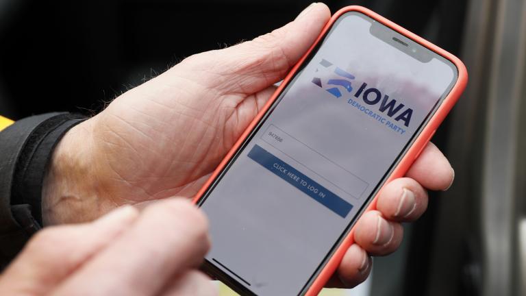 Precinct captain Carl Voss, of Des Moines, Iowa, holds his iPhone that shows the Iowa Democratic Party’s caucus reporting app Tuesday, Feb. 4, 2020, in Des Moines, Iowa. (AP Photo / Charlie Neibergall)