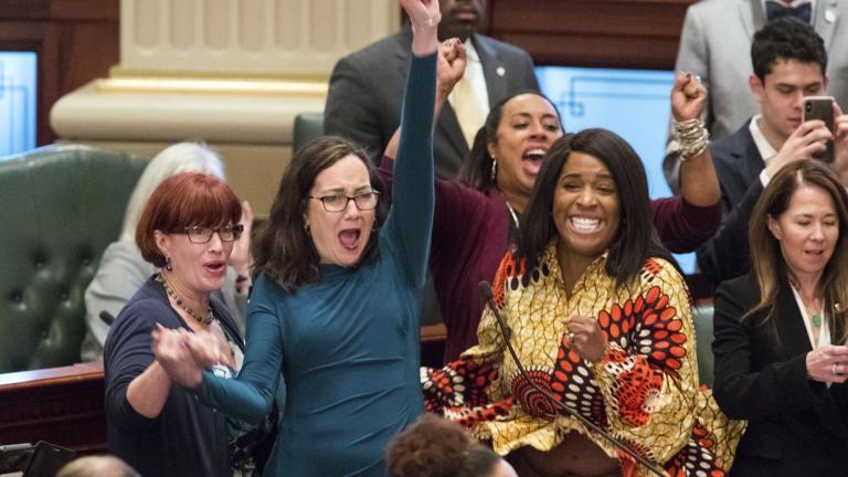 Illinois state Rep. Kelly Cassidy, D-Chicago, throws her fist in the air as she celebrates with Illinois state Sen. Heather Steans, D-Chicago, left, and Rep. Jehan Gordon-Booth, D-Peoria, as they watch the final votes come in for their bill to legalize recreational marijuana use in the Illinois House chambers Friday, May 31, 2019. The 66-47 vote sends the bill to Gov. J.B. Pritzker who indicated he will sign it. (Ted Schurter / The State Journal-Register via AP)