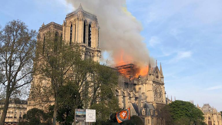 Notre Dame Cathedral is burning in Paris on Monday, April 15, 2019. Massive plumes of yellow brown smoke is filling the air above Notre Dame Cathedral and ash is falling on tourists and others around the island that marks the center of Paris. (AP Photo)