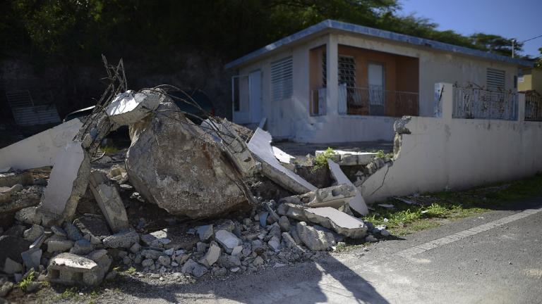 A big rock sits amid the rubble of the low wall it destroyed when it rolled down from a nearby cliff during a magnitude 5.9 earthquake in Guanica, Puerto Rico, Saturday, Jan. 11, 2020. (AP Photo / Carlos Giusti)