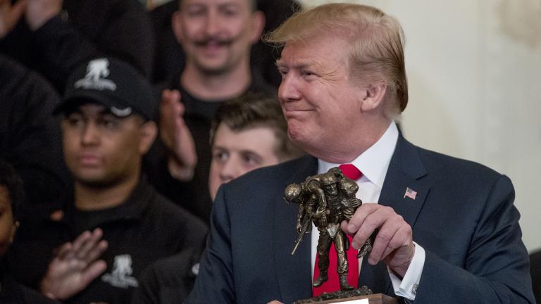 President Donald Trump holds up a statue of the Wounded Warrior Project logo presented to him during a Wounded Warrior Project Soldier Ride event in the East Room of the White House, Thursday, April 18, 2019, in Washington. (AP Photo / Andrew Harnik)