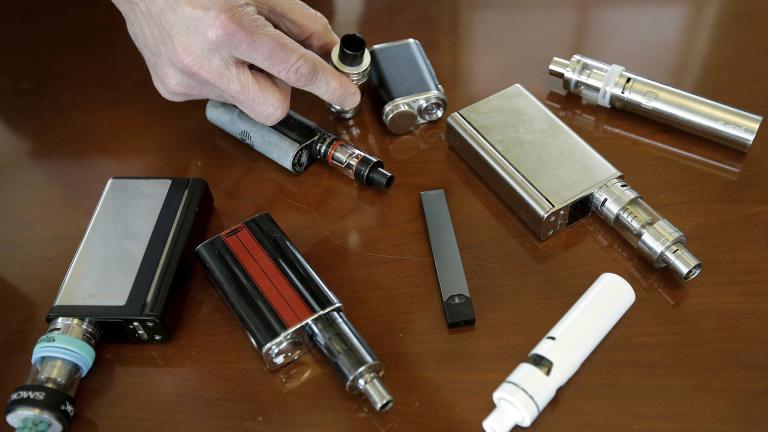 In this Tuesday, April 10, 2018 photo, a high school principal displays vaping devices that were confiscated from students at the school in Massachusetts. (AP Photo / Steven Senne)