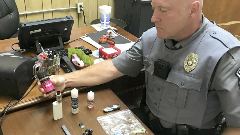 In this Sept. 23, 2019 photo, Bristol, Va., Police Officer Marlin Goff shows some of the vaping products he has confiscated from students at a high school. (Tim Dotson / Bristol Herald Courier via AP)