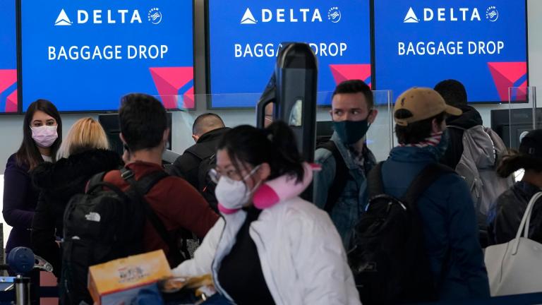 In this Dec. 22, 2020 file photo, people wait in line at a Delta Air Lines gate at San Francisco International Airport during the coronavirus pandemic in San Francisco. (AP Photo / Jeff Chiu, file)