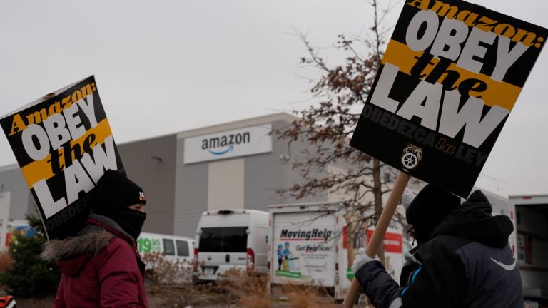 Strikers hold signs during a strike at Skokie (DIL7) Amazon Delivery station in Skokie, Ill., Thursday, Dec. 19, 2024. (AP Photo / Nam Y. Huh)