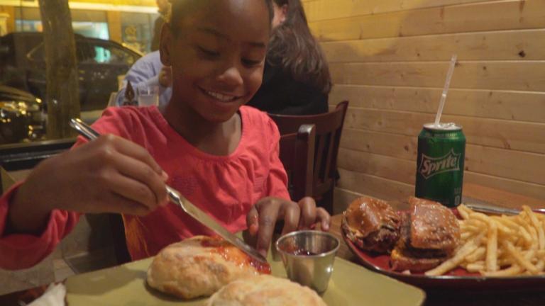 A girl eats at Luella’s Southern Kitchen. (WTTW News)