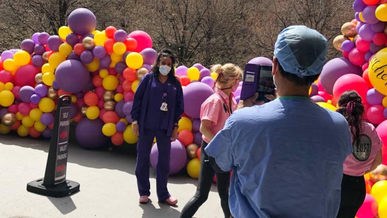 Respiratory therapist Jacob Thomas takes a photo of his colleague Felicia Smith in front of Luft Balloons’ installation at Advocate Illinois Masonic Medical Center. (Patty Wetli / WTTW News)