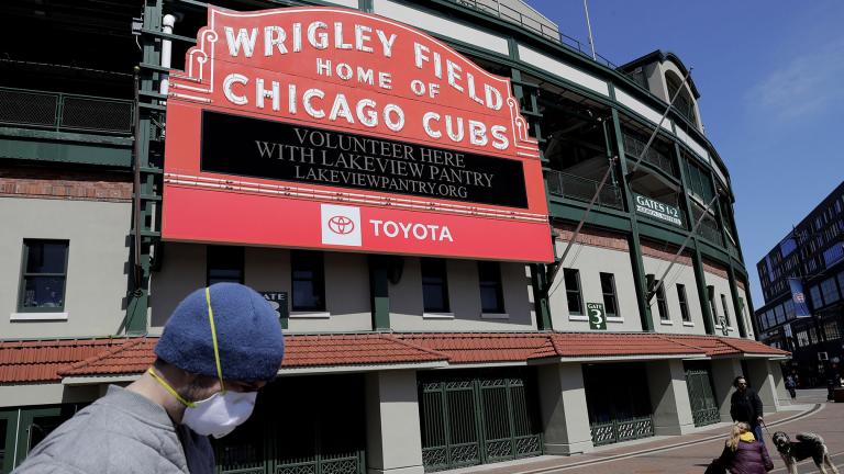 In this April 16, 2020 file photo, Wrigley Field’s marquee displays Lakeview Pantry volunteer information in Chicago. The Chicago Cubs are instituting pay cuts because of the coronavirus crisis, but there will be no furloughs through the end of June. (AP Photo / Nam Y. Huh, File)