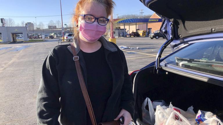Hairdresser Chelsea Woody stands outside her car at a grocery store Tuesday, Jan. 11, 2022, in Charleston, W.Va. For the first time in half a year, families on Jan. 14, are going without a monthly deposit from the federal child tax credit. Woody, a single mother, relied on the check to help raise her young son. (AP Photo / John Raby)