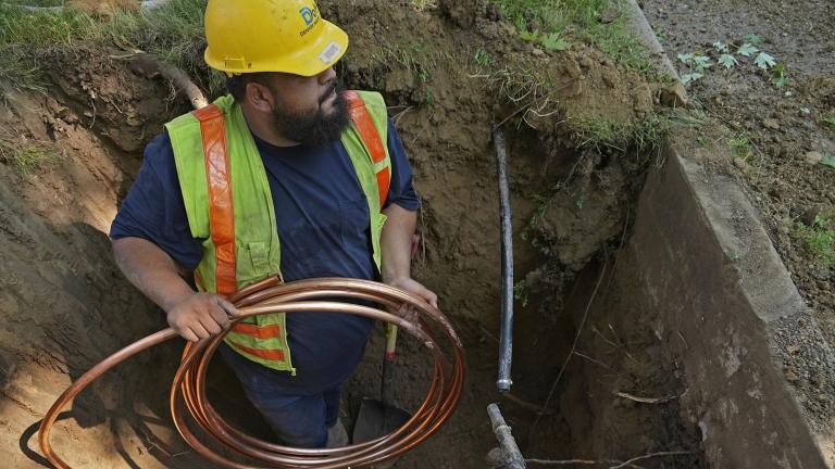A worker with Denver Water prepares to pass a new copper water service line from a residential water meter to the water main on Thursday, June 17, 2021, in Denver. (AP Photo / Brittany Peterson)