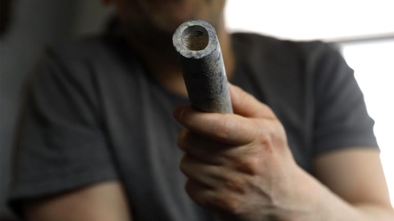 Troy Hernandez, an environmental justice activist with Pilsen Environmental Rights and Reform Organization shows a piece of lead pipe obtained from his residence during his home renovation, Friday, April 9, 2021 in Chicago's Pilsen neighborhood. Hernandez recently spent $15,000 to replace the lead service lines bringing water into his home. (AP Photo / Shafkat Anowar)