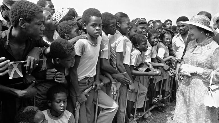 Jamaican school children greet Queen Elizabeth II at the National Heroes Monument in Kingston, Jamaica, on Feb. 14, 1983, during the second day of the queen's visit to the former British colony. (AP Photo/  Kathy Willens, File)