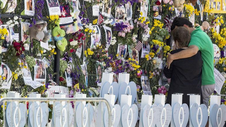 FILE - In this Thursday July 8, 2021, file photo, people mourn at the memorial wall for the victims of the Champlain Towers South collapse, in Surfside, Fla. (Pedro Portal / Miami Herald via AP, File)