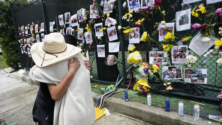 People embrace at a make-shift memorial outside St. Joseph Catholic Church, in Surfside, Fla., Monday, June 28, 2021, near the collapsed building for people still missing or dead. (AP Photo / Gerald Herbert)