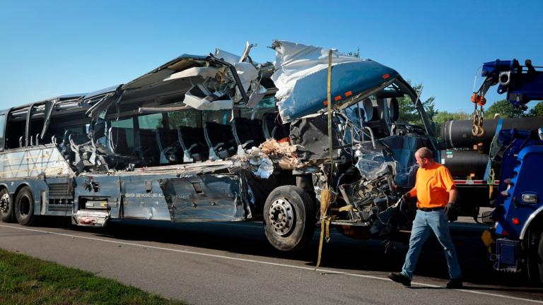 A damaged Greyhound bus is prepared for transport on Wednesday, July 12, 2023, from the scene of a fatal wreck on westbound Interstate 70 after the bus collided with a tractor-trailer near Highland, Ill. (Christian Gooden / St. Louis Post-Dispatch via AP)