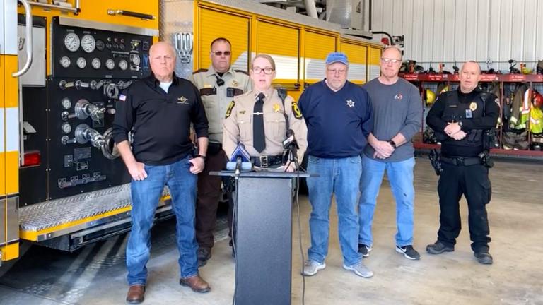 In this image made from video provided by Illinois State Police Troop 6, Illinois State Police Capt. Jody Huffman, at podium, speaks during a news conference about the five people, including three children, who were killed Monday, March 11, 2024, after a school bus and semitruck collided on a highway in western Illinois. (Illinois State Police Troop 6 via AP)
