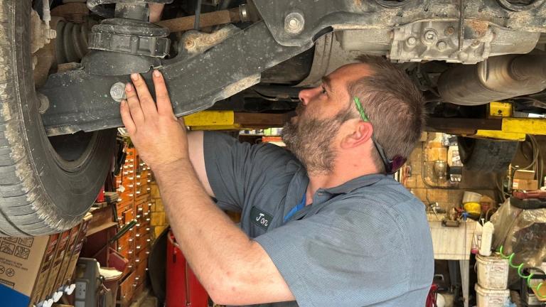 Mechanic Jon Guthrie inspects the underside of a 2014 Honda Ridgeline pickup truck at Japanese Auto Professional Service in Ann Arbor, Michigan. (AP Photo / Tom Krisher)