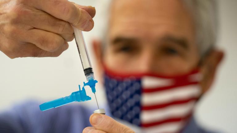  Dr. Sydney Sewall fills a syringe with the COVID-19 vaccine at the Augusta Armory, Dec. 21, 2021, in Augusta, Maine. (AP Photo/Robert F. Bukaty, File)