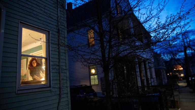 FILE - McKenna Shuster works on a linocut art print which she does as a hobby in her home on the last night of a two-week self-isolation while recovering from symptoms of COVID-19 in Somerville, Mass., on March 26, 2020. (David Goldman / AP Photo, File)