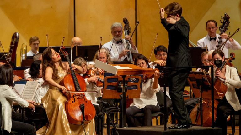 Alisa Weilerstein, left in gold gown, and the Chicago Symphony Orchestra are conducted by Joshua Weilerstein on Aug. 17, 2023, at the Ravinia Festival. (Emily Waler / Ravinia Festival) 