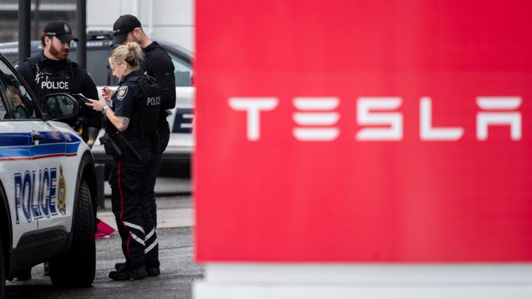 Officers from Ottawa Police Service (OPS) are seen at a Tesla Service and Showroom centre after it was damaged with pink spray paint in Ottawa, on Monday, March 31, 2025. (Spencer Colby / The Canadian Press via AP)
